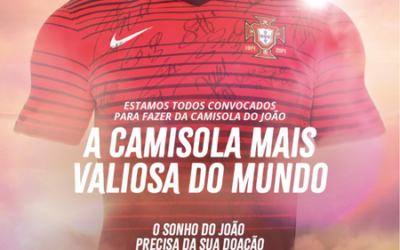 Das Bild zeigt ein rotes Fußballtrikot mit Unterschriften, begleitet von Text: "A CAMISOLA MAIS VALIOSA DO MUNDO" (Das wertvollste Trikot der Welt).